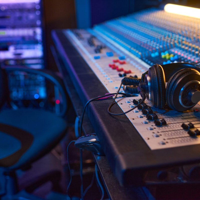 Close-up of sound mixing board with headphones on it for musical producer in studio