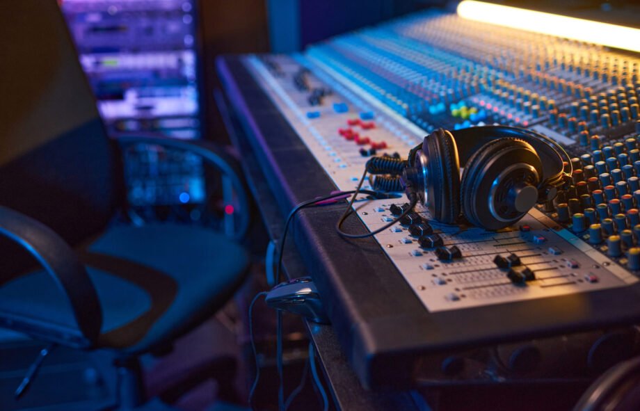 Close-up of sound mixing board with headphones on it for musical producer in studio